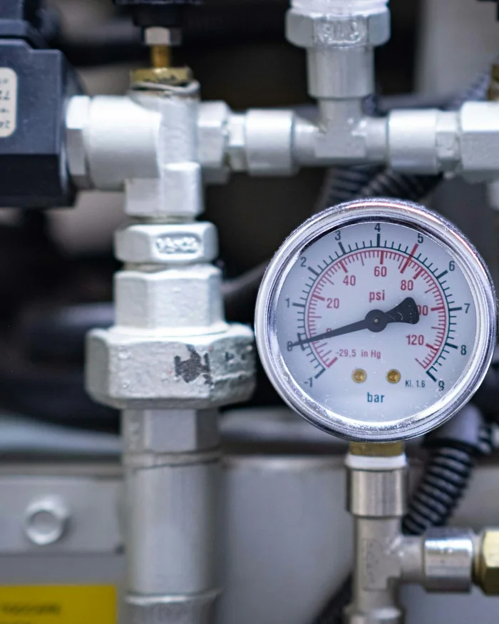 A pressure gauge and brass fittings on a pump system.